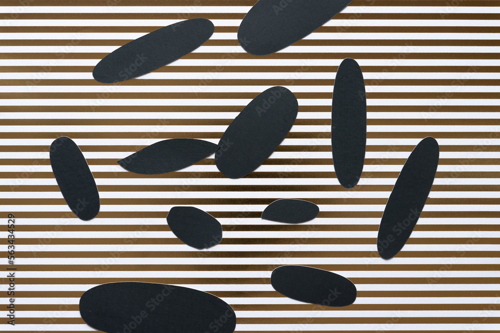 various grungy cut paper shapes (mostly oval or ovoid) on scrapbook paper with gold stripes various grungy cut paper shapes (mostly oval or ovoid) on scrapbook paper with gold stripes