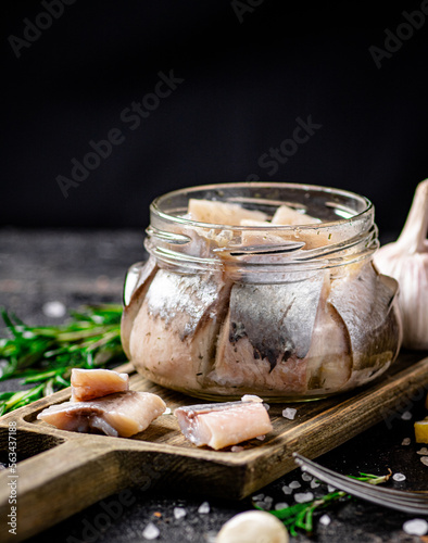 Salted herring glass jar with a swist of rosemary. photo