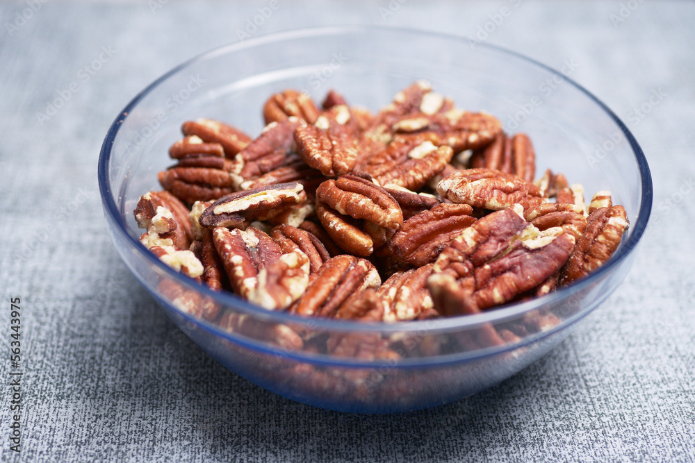 Tasty pecan-nut on a wooden in a bowl on table Tasty pecan-nut on a wooden in a bowl on table