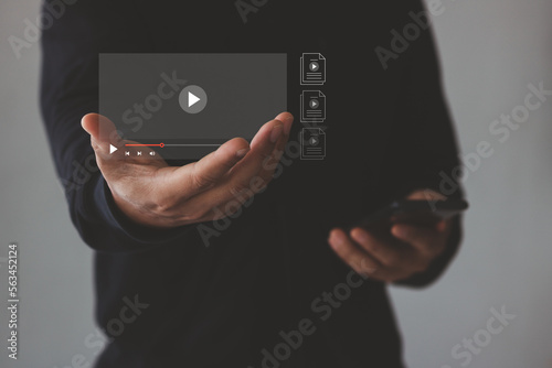 Person showing Video on virtual screen to watch online VOD streaming of movie, TV via smartphone, Training, learning, teaching, virtual reality used in online video conferencing, and Online streaming.