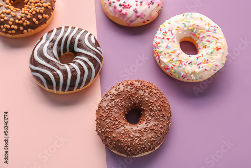 Delicious glazed donuts on color background