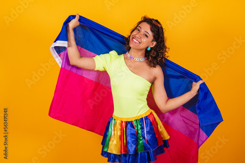 beautiful afro american brazilian woman in carnival clothes holding bisexual lgbt flag. Bisexual pride. photo