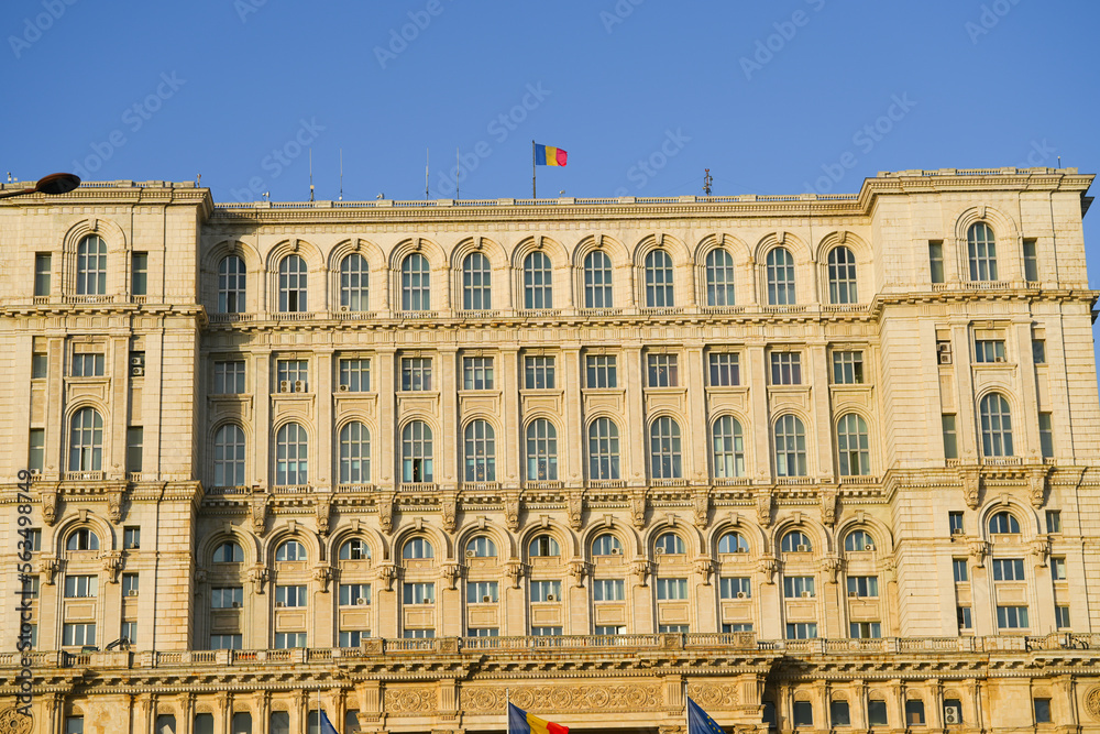 he Romanian flag waving on the Parliament Palace on a sunny day.