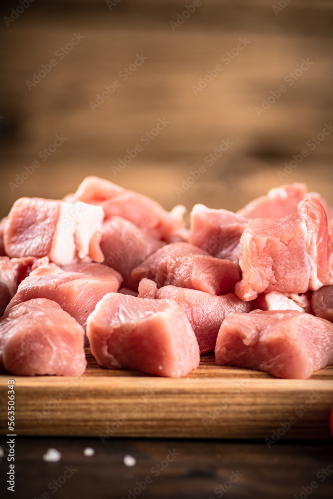 Pieces of raw pork on a cutting board.