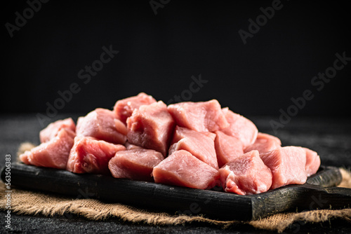A bunch of chopped raw pork on a cutting board. 