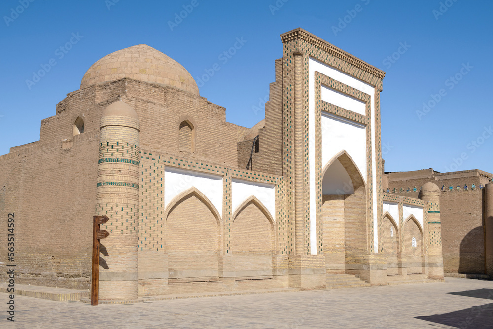 Facade of the ancient madrasah of Mukhammad Amin Inak on a sunny day. Khiva, Uzbekistan