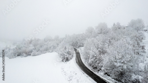 Winter snowstorm on Castelletto, Vernasca, Piacenza, Italy, covered with snow, drone aerial view photo