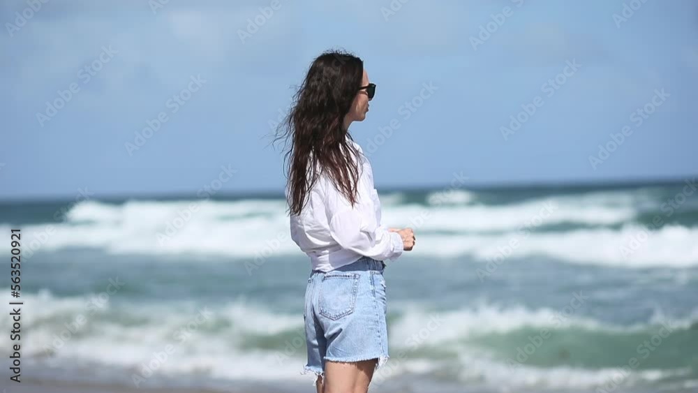 Young beautiful woman in windy weather on the beach Young beautiful woman in windy weather on the beach