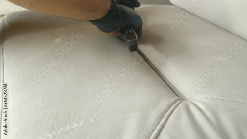 CLOSE UP: Brushing the sofa surface to remove dirt and disperse cleaning product. The initial deep cleaning process of upholstered furniture as a mandatory household chore during spring-cleaning. photo