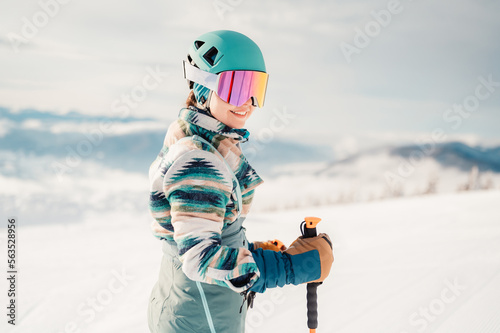 Obraz na płótnie Woman in skiing clothes with helmet and ski googles on her head with ski sticks