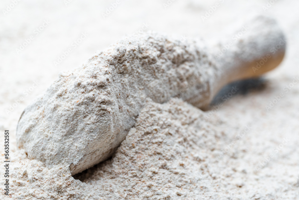 Baking background with flour in wooden scoop Baking background with flour in wooden scoop