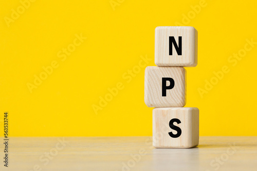 concept word NPS. Net Promoter Score. wooden cubes. TEXT. YELLOW BACKGROUND. Business concept. Copy space
