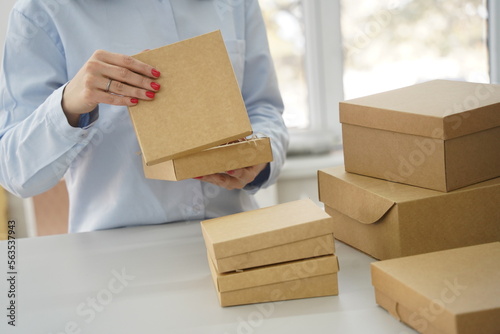 A woman holds cardboard boxes for parcels and delivery