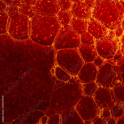 yellow soap bubbles cover a red background sprinkled with glitter creating an abstract image