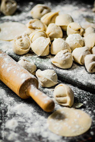 Homemade dumplings on a cutting board with flour. 