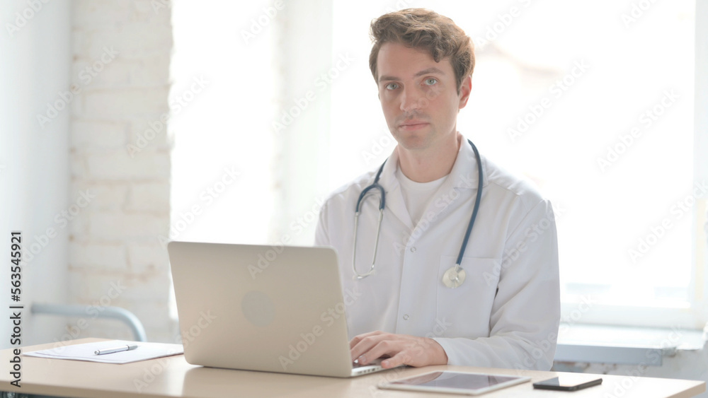 Young Doctor Looking at Camera While sitting in Clinic Young Doctor Looking at Camera While sitting in Clinic