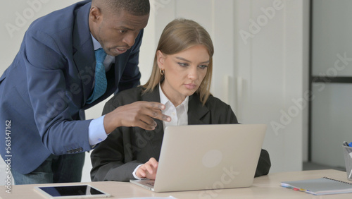 Standing African Businessman Helping Female Employee at Work, Guiding © stockbakers