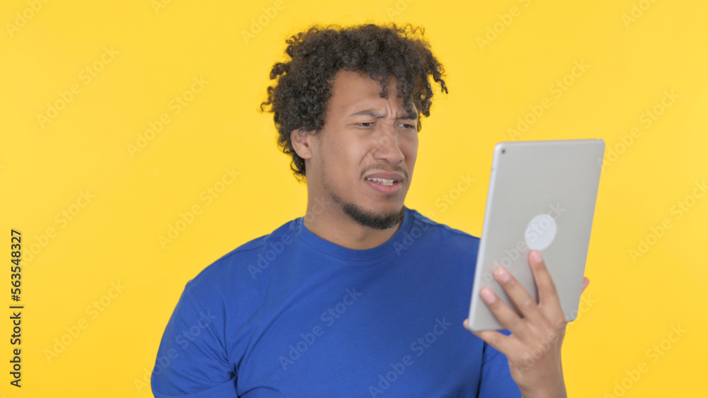 African Man Reacting to Loss on Tablet on Yellow Background African Man Reacting to Loss on Tablet on Yellow Background