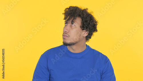 African Man Feeling Scared, Frightened on Yellow Background © stockbakers