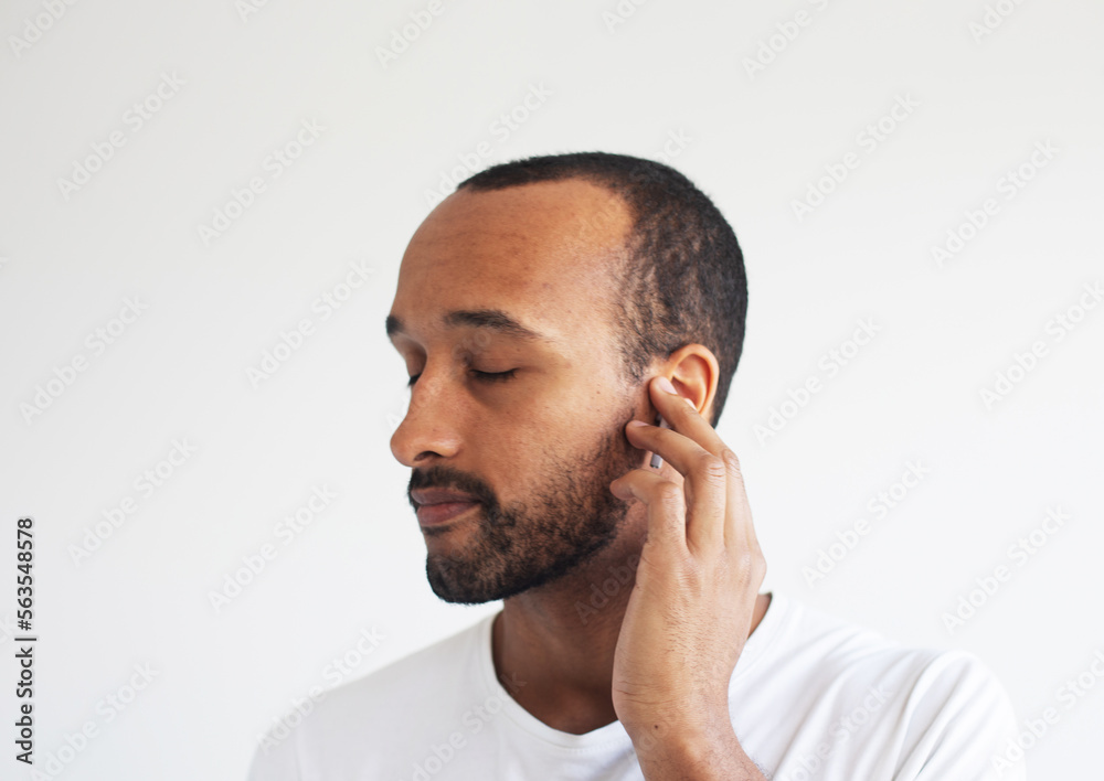 Obraz premium A young unshaven man on a light gray background. African American.