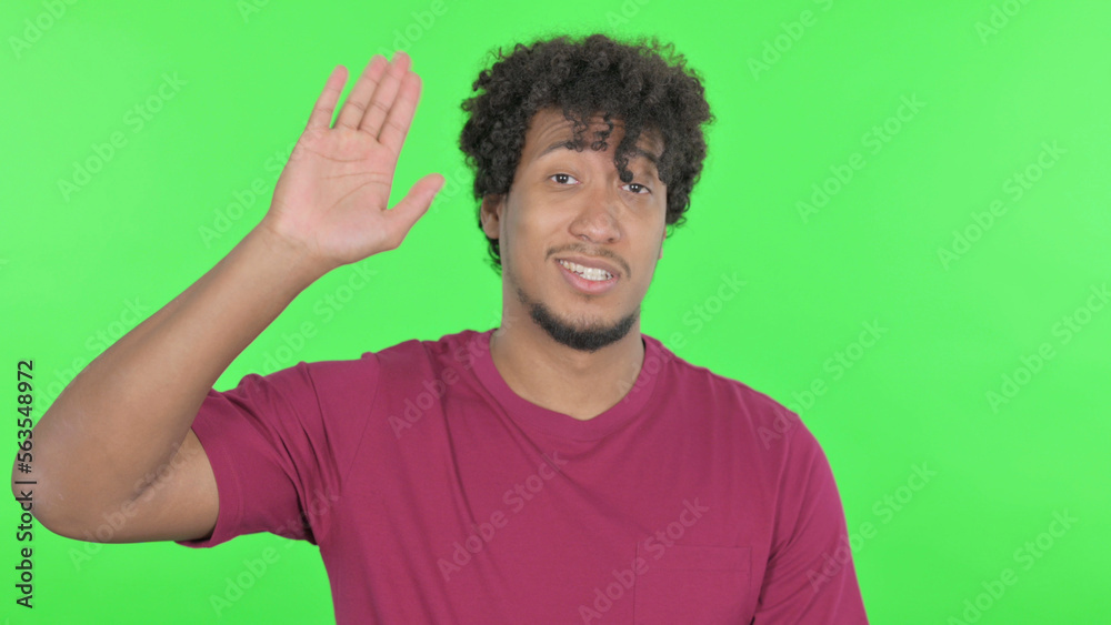 African Man Waving Hand to Say Hello on Green Background African Man Waving Hand to Say Hello on Green Background
