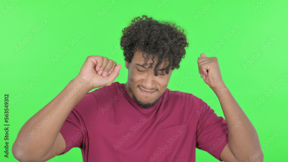African Man Dancing in Joy on Green Background African Man Dancing in Joy on Green Background