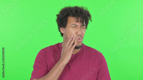 African Man Having Toothache on Green Background