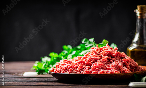 Minced meat on a plate on the table with parsley. 