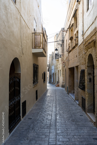 Typical narrow street with an ancient stone buildings in Mdina