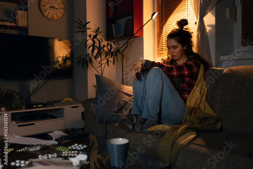 Obraz na plátně Sloppy depressed young Caucasian woman is sitting on sofa suffering from psychological problems