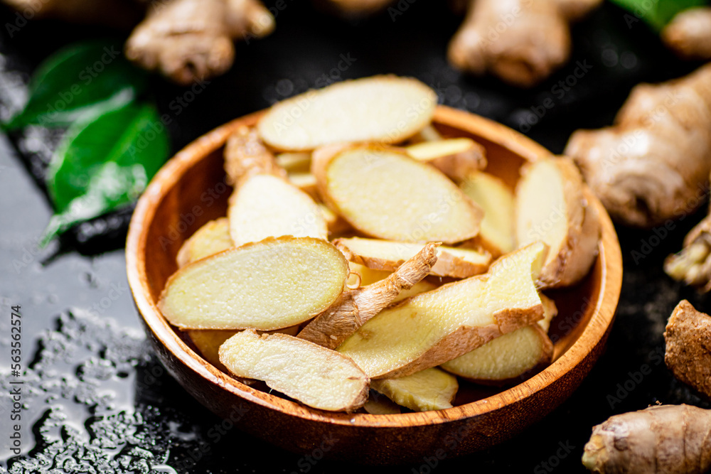 Pieces of fresh ginger root in a wooden plate. Pieces of fresh ginger root in a wooden plate.
