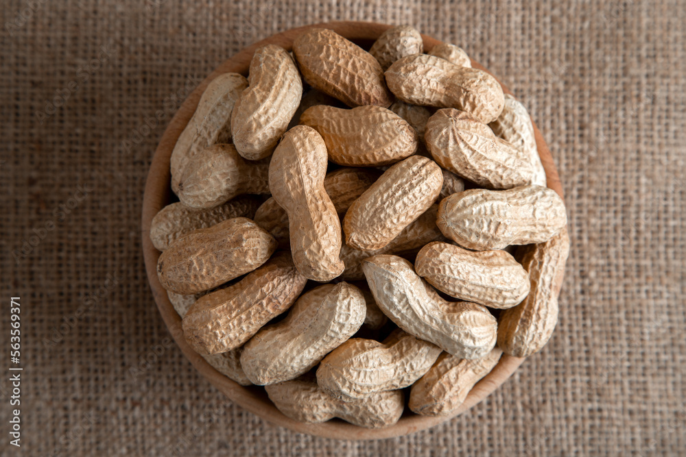 Bowl full of shelled peanuts on burlap,top view Bowl full of shelled peanuts on burlap,top view