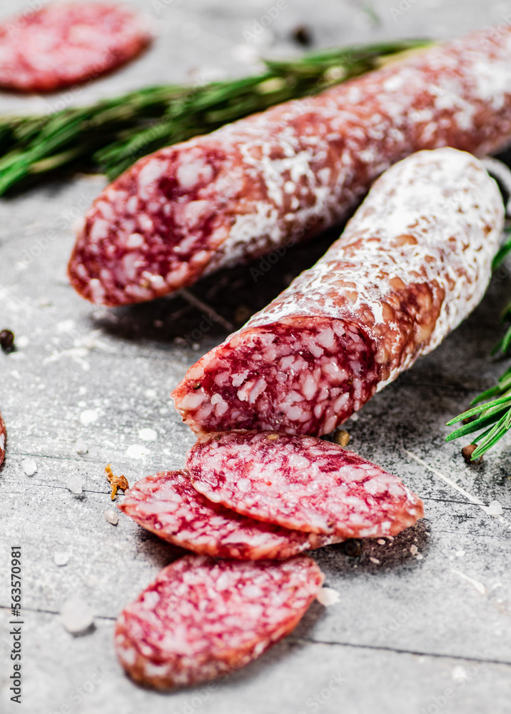 Pieces of salami sausage with sprigs of rosemary. Pieces of salami sausage with sprigs of rosemary.