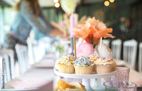 Fresh cupcakes with whipped cream and devorative flower icing served on a plate on party table, wedding,baby shower,high tea, Birthday holiday photo