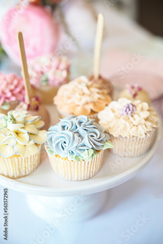 Fresh cupcakes with whipped cream and devorative flower icing served on a plate on party table, wedding,baby shower,high tea, Birthday holiday photo