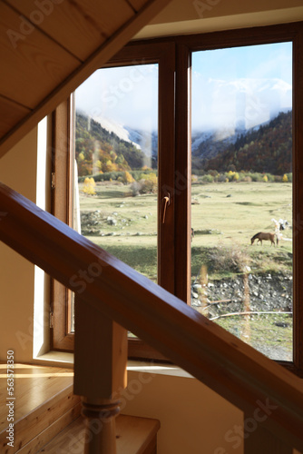 Beautiful view of picturesque landscape with high mountains from window in cozy room