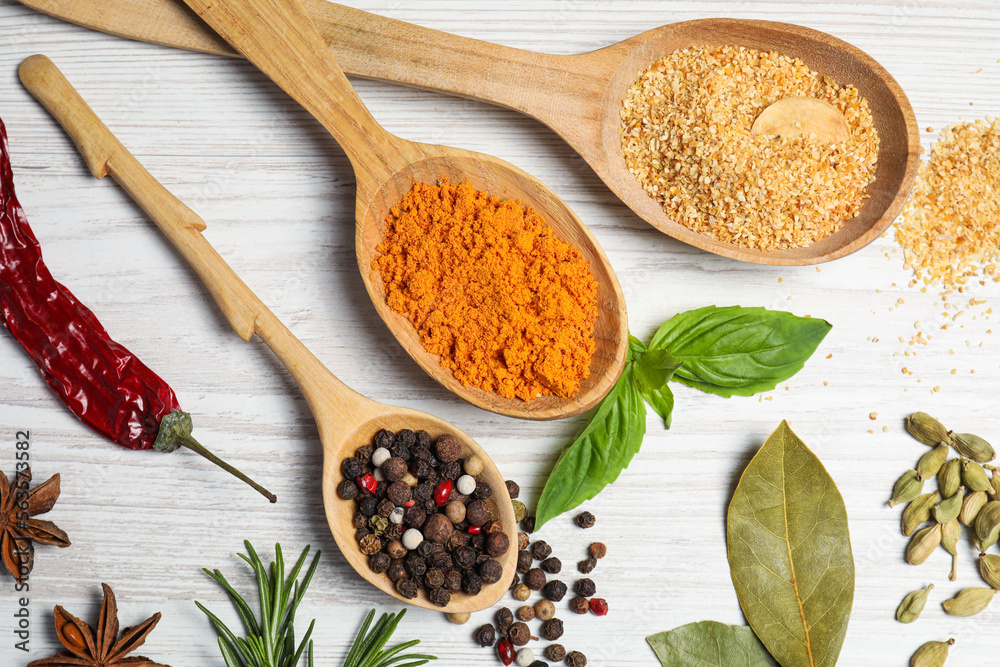 Spoons with different spices and herbs on white wooden table, flat lay Spoons with different spices and herbs on white wooden table, flat lay