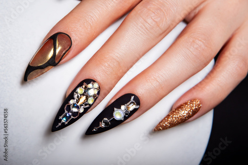 Black and gold manicure with diamonds.
