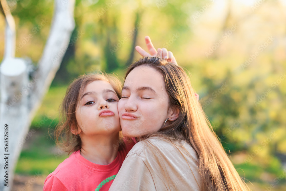 Two Cute little girls hugging and laughing at the countryside. Happy kids spending time outdoors Two Cute little girls hugging and laughing at the countryside. Happy kids spending time outdoors