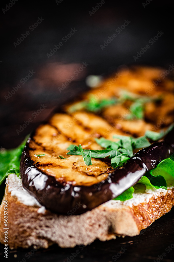 One sandwich with eggplant grilled on the table. 