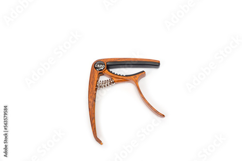 Metal capo for guitar with spring painted wood.
