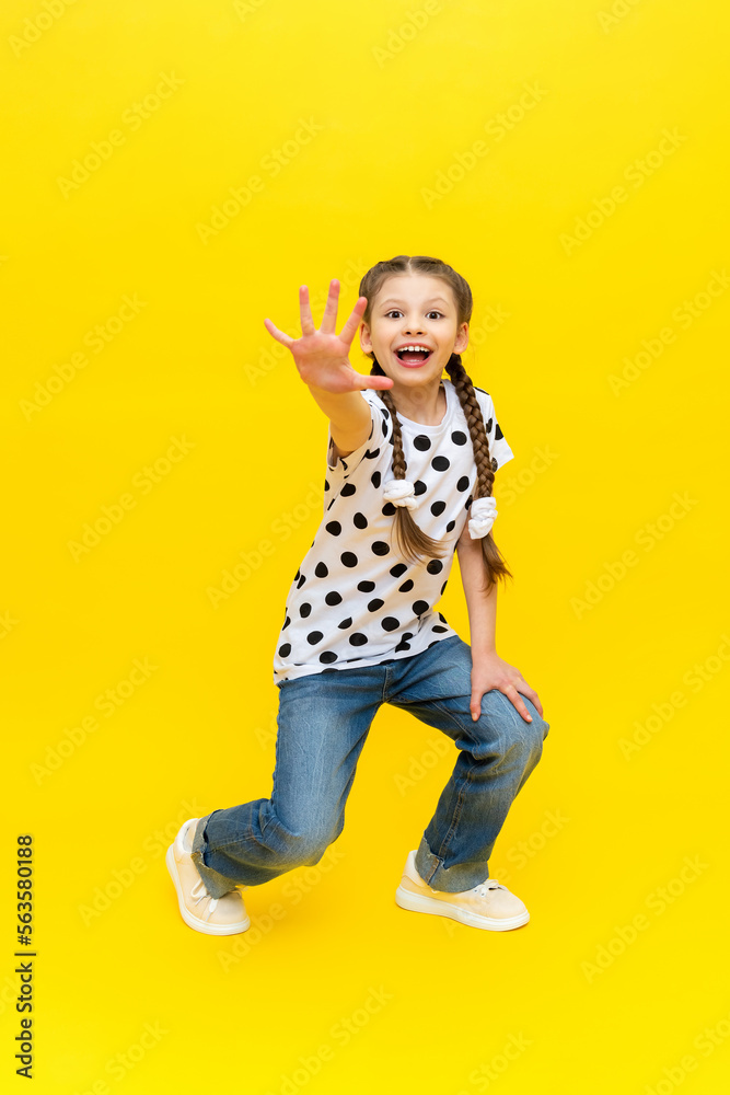 A teenage girl in a very good mood and a joyful smile on a yellow background. A teenage girl in a very good mood and a joyful smile on a yellow background.