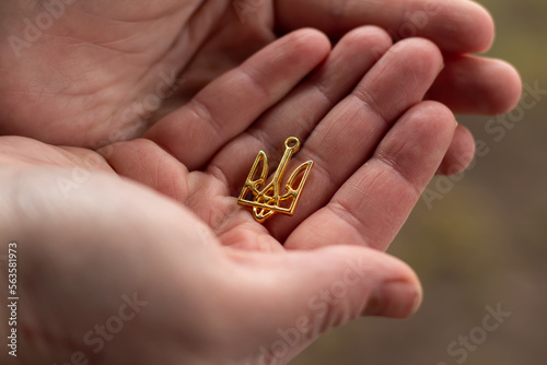 Coat of arms of the country of Ukraine trident, close-up in the hands.