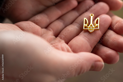 Coat of arms of the country of Ukraine trident, close-up in the hands.