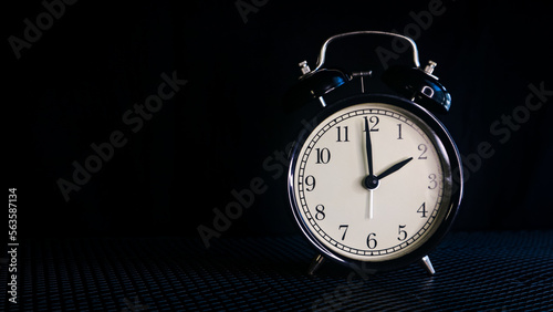 Background photo of an alarm clock showing 2:00