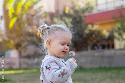 little girl holding dandelion