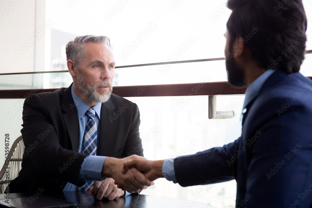 Senior executive or CEO talking and discussing for negotiation agreement and deal with partner about project and handshake together for success at office, business people meeting with consultant. Senior executive or CEO talking and discussing for negotiation agreement and deal with partner about project and handshake together for success at office, business people meeting with consultant.