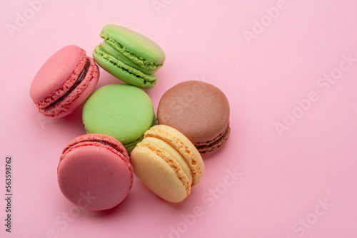 Colorful french macarons isolated on pink background.