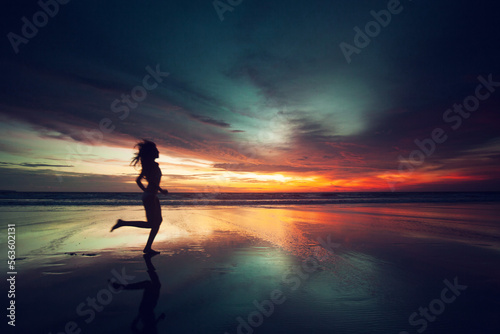 Woman running on beach sunset