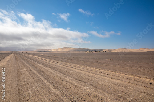 Gravel road with dunes in Skeleton Coast Park, Namibia. 